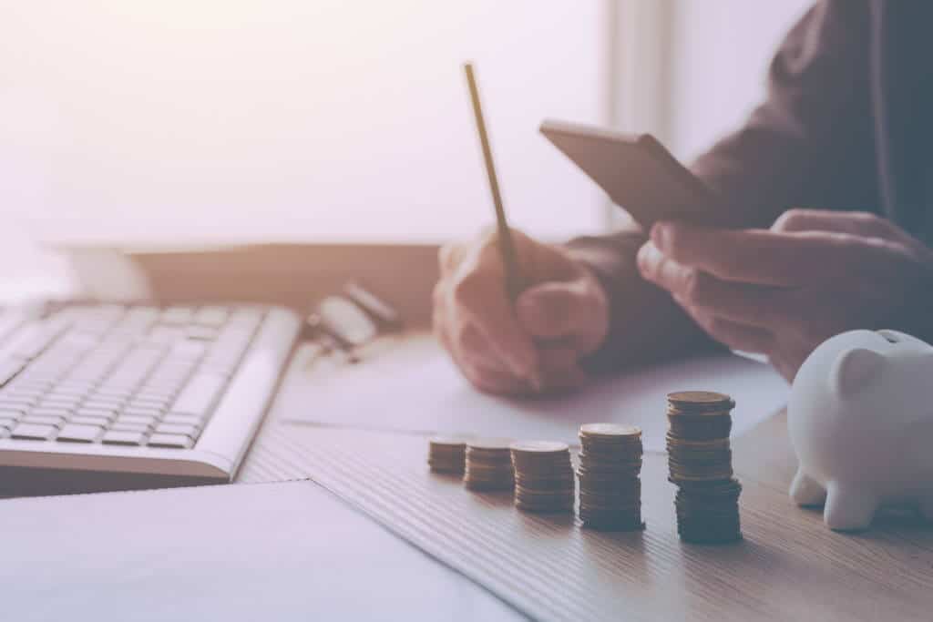 Home budget calculation, man working financial figures. Salary, expenses, taxes and expenditure. Retro toned image with selective focus.